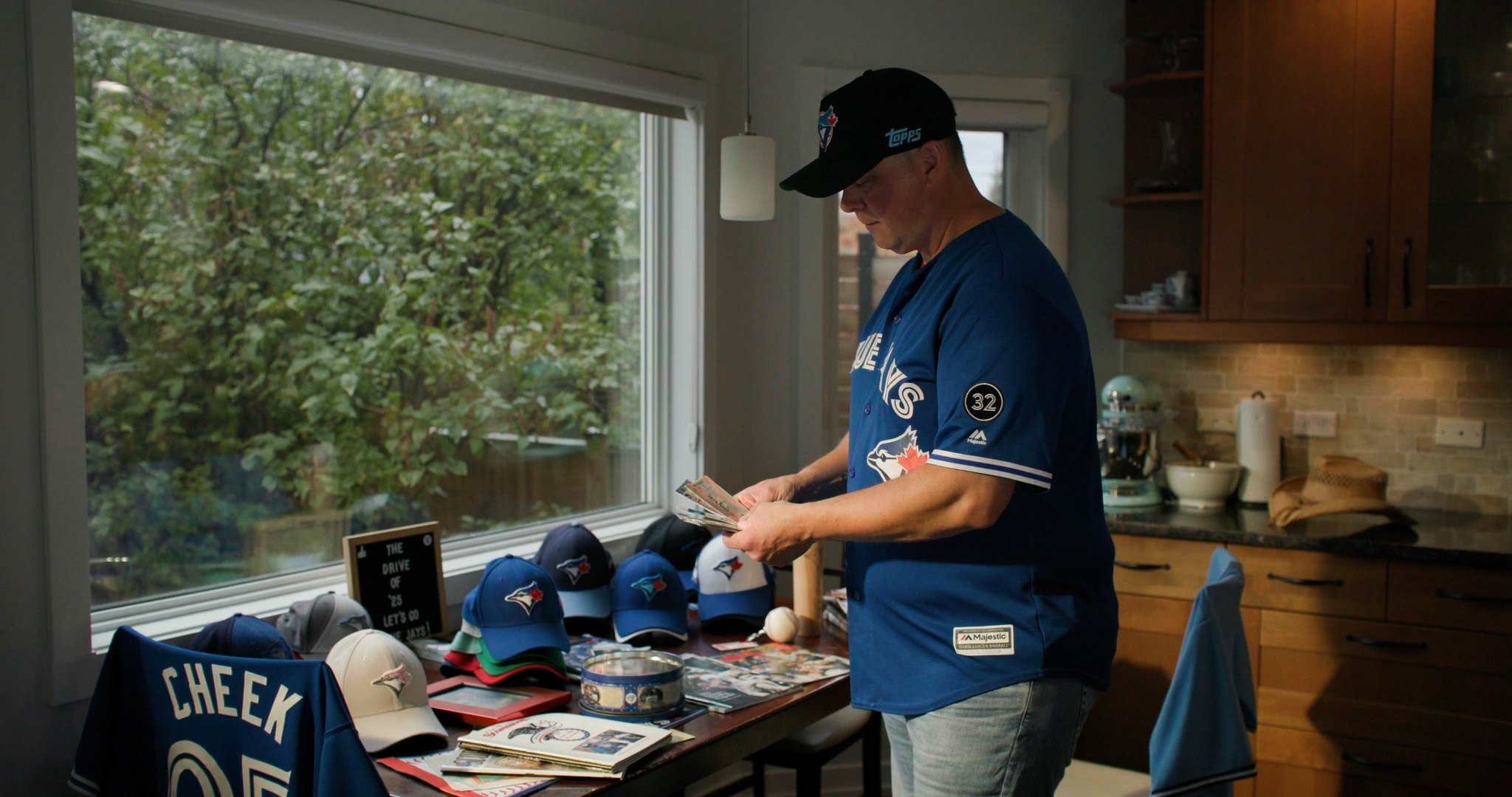 Blue Jays fan with jersey, caps and memorabilia collection — ad frame