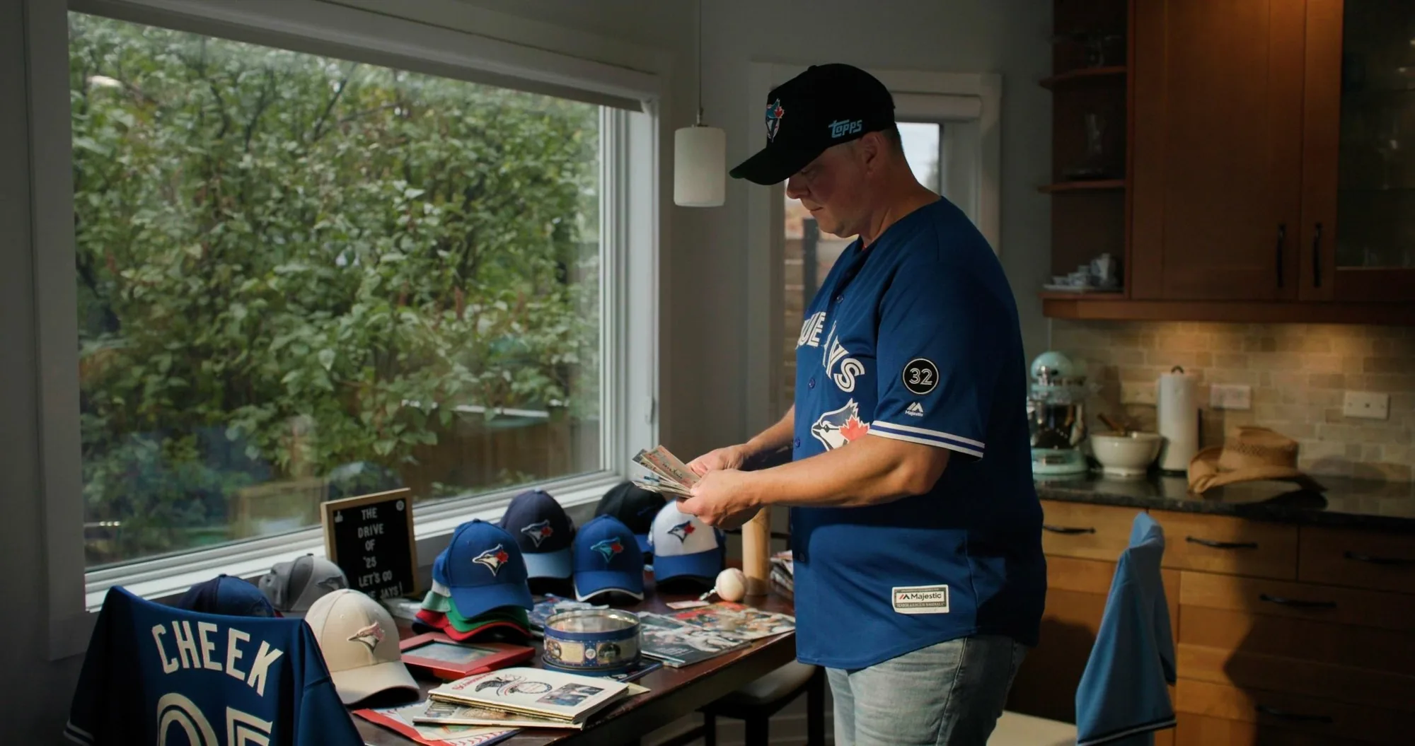 Blue Jays fan with jersey, caps and memorabilia collection — ad frame