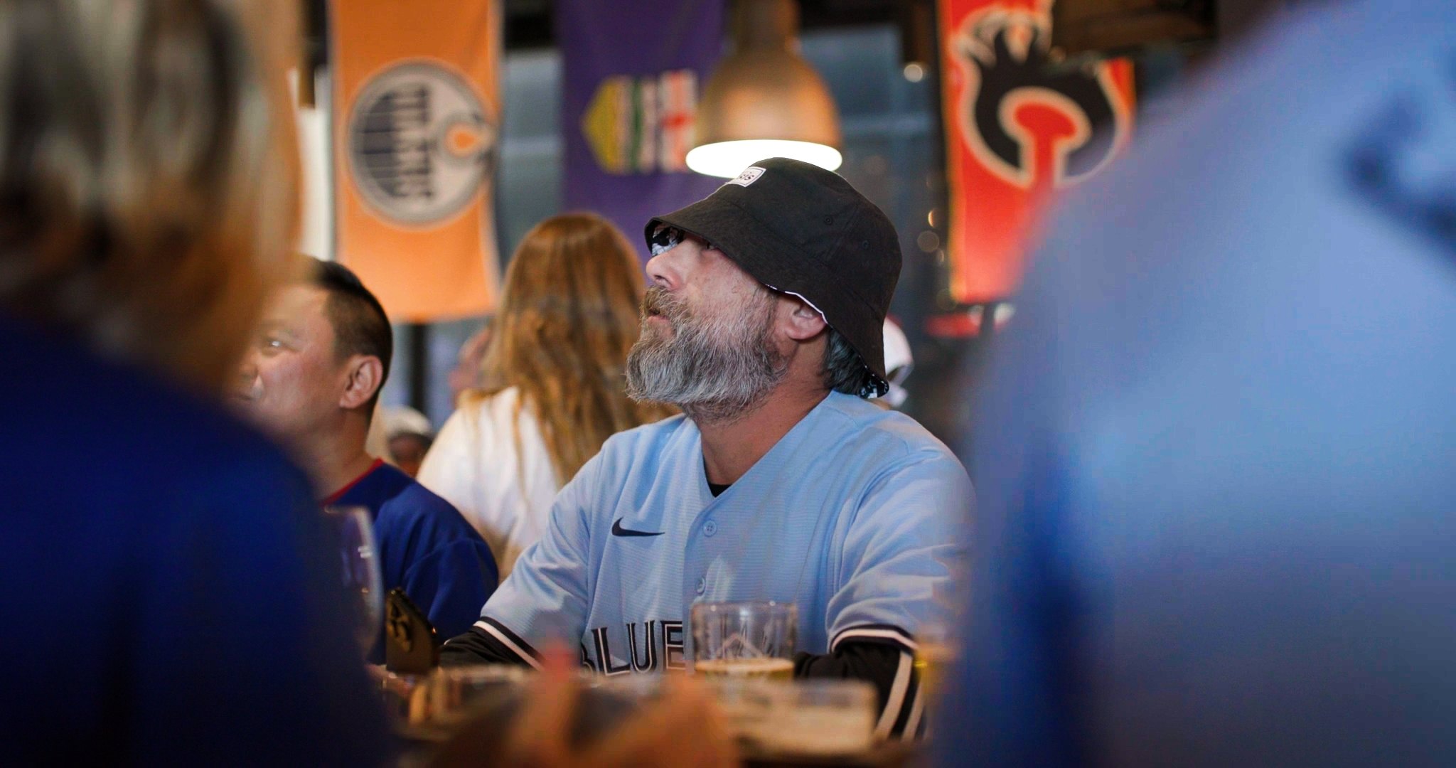 Fan in Blue Jays jersey watching the game intently — ad frame