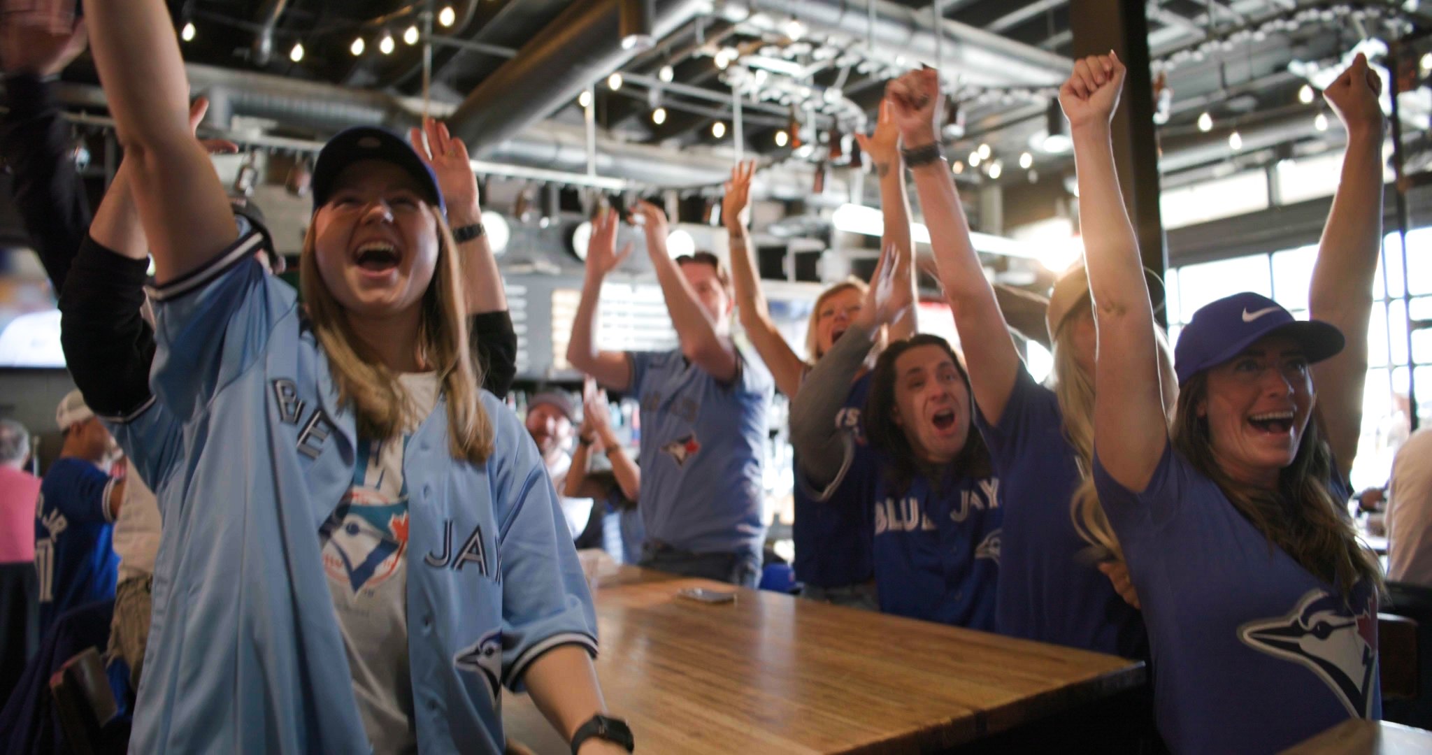 Fans with arms raised at an outdoor Calgary venue — ad frame