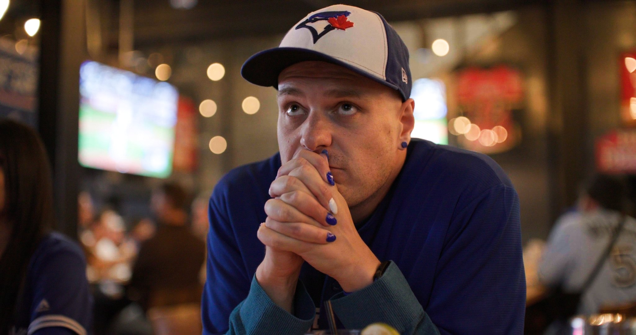 The final ad frame: Chris Doucher with praying hands at the bar — made the final Blue Jays cut