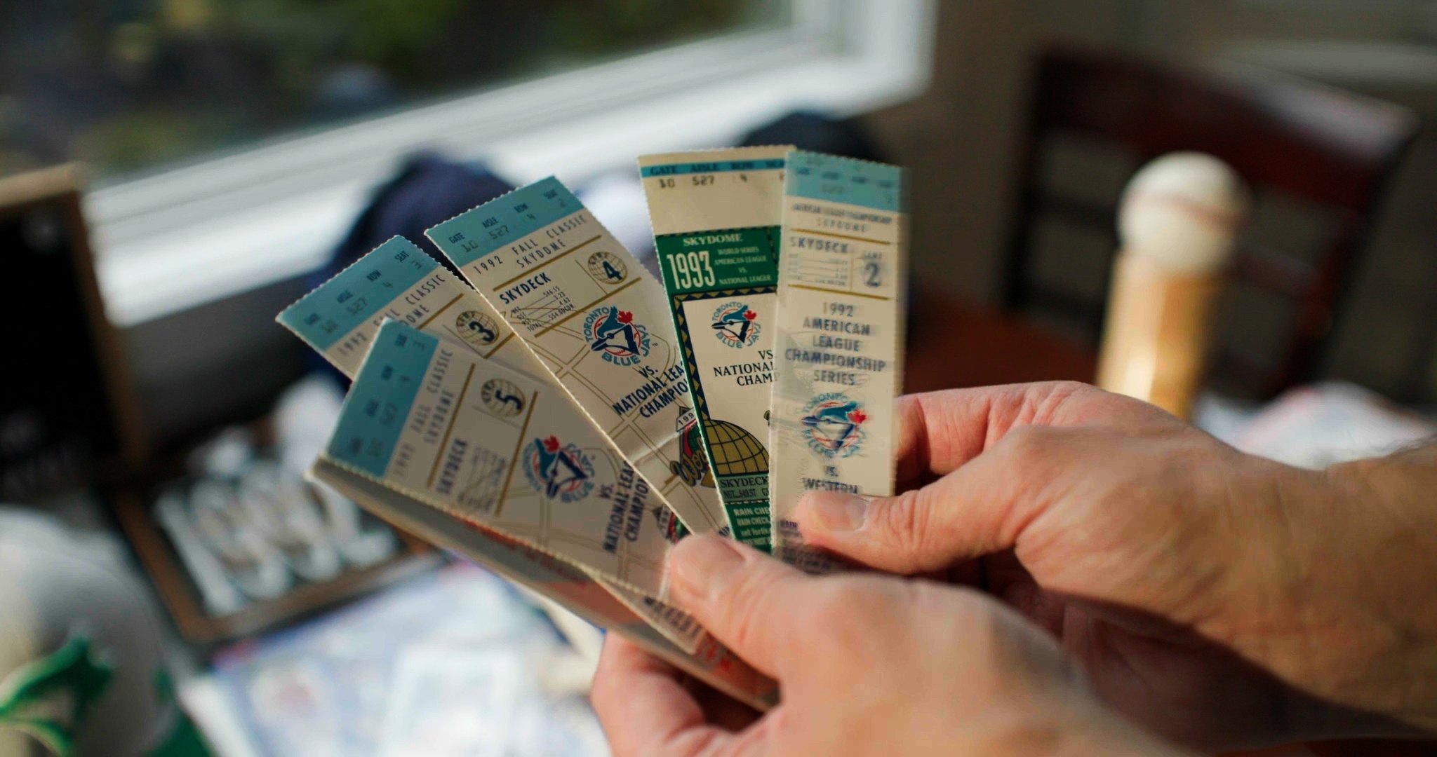 Hands holding 1992 and 1993 Blue Jays World Series Skydome tickets — ad frame