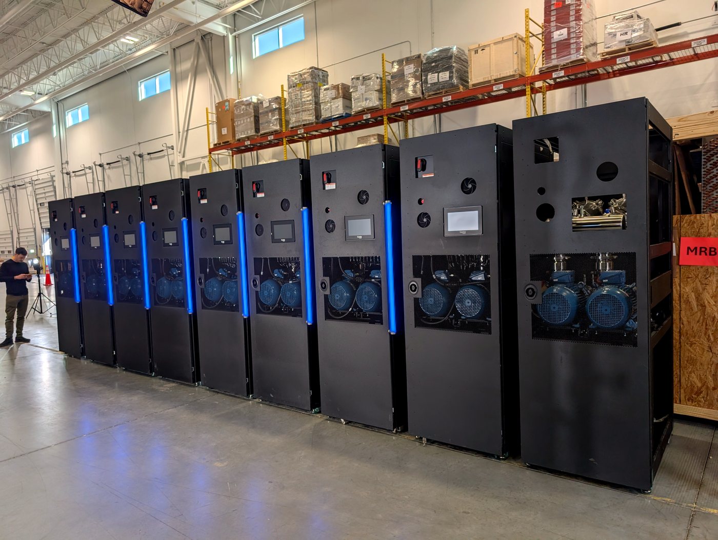 Row of CoolIT cooling cabinets glowing blue in the facility, Calgary