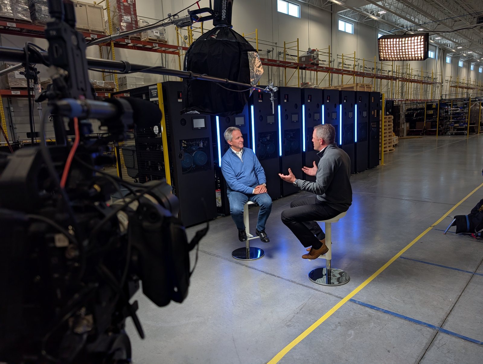 Filming the two-person leadership interview on the blue-lit set, CoolIT Calgary