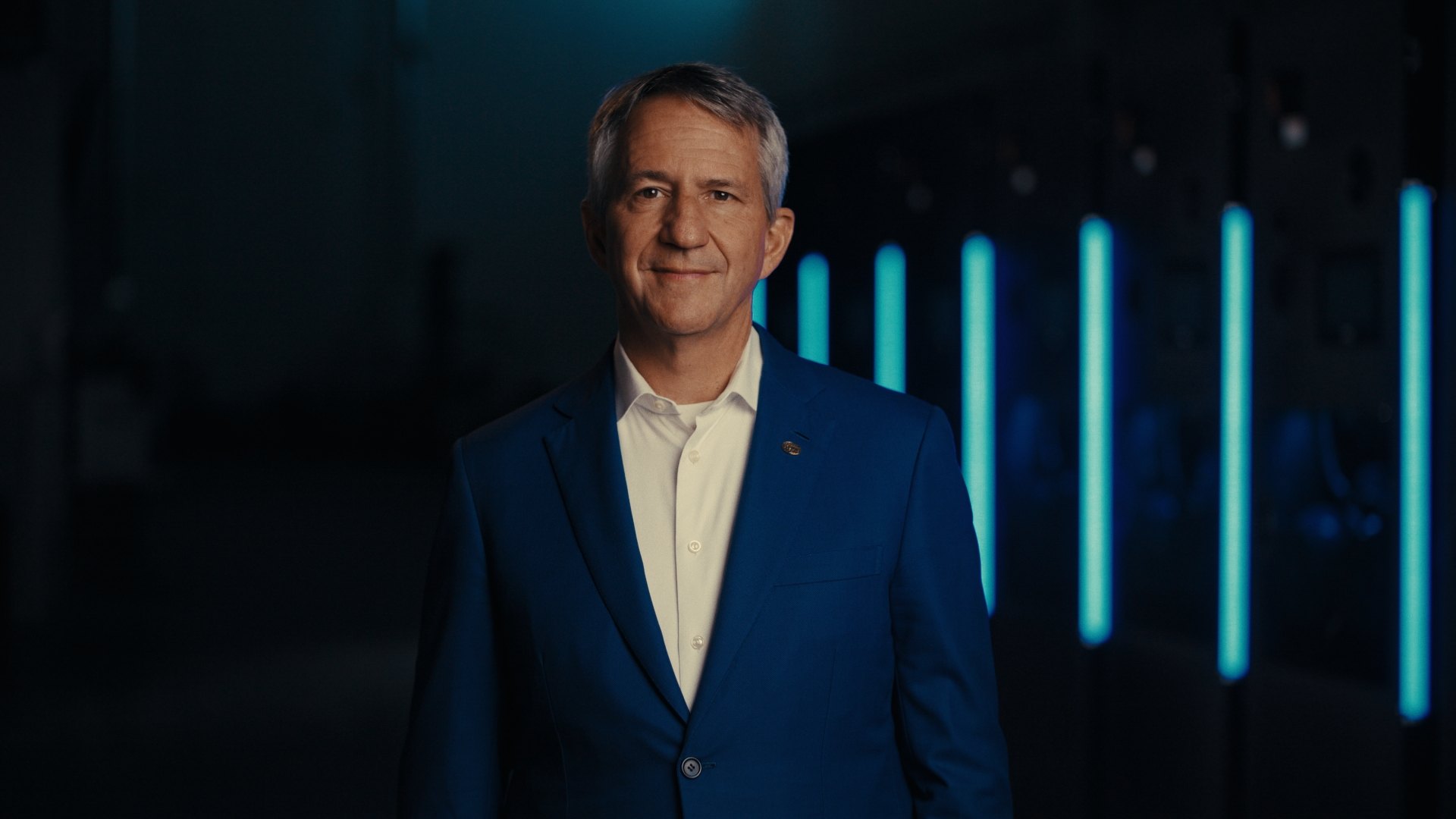 Ecolab's CEO on camera under cyan light bars during the CoolIT acquisition announcement, filmed in Calgary by DCFOTOFILM