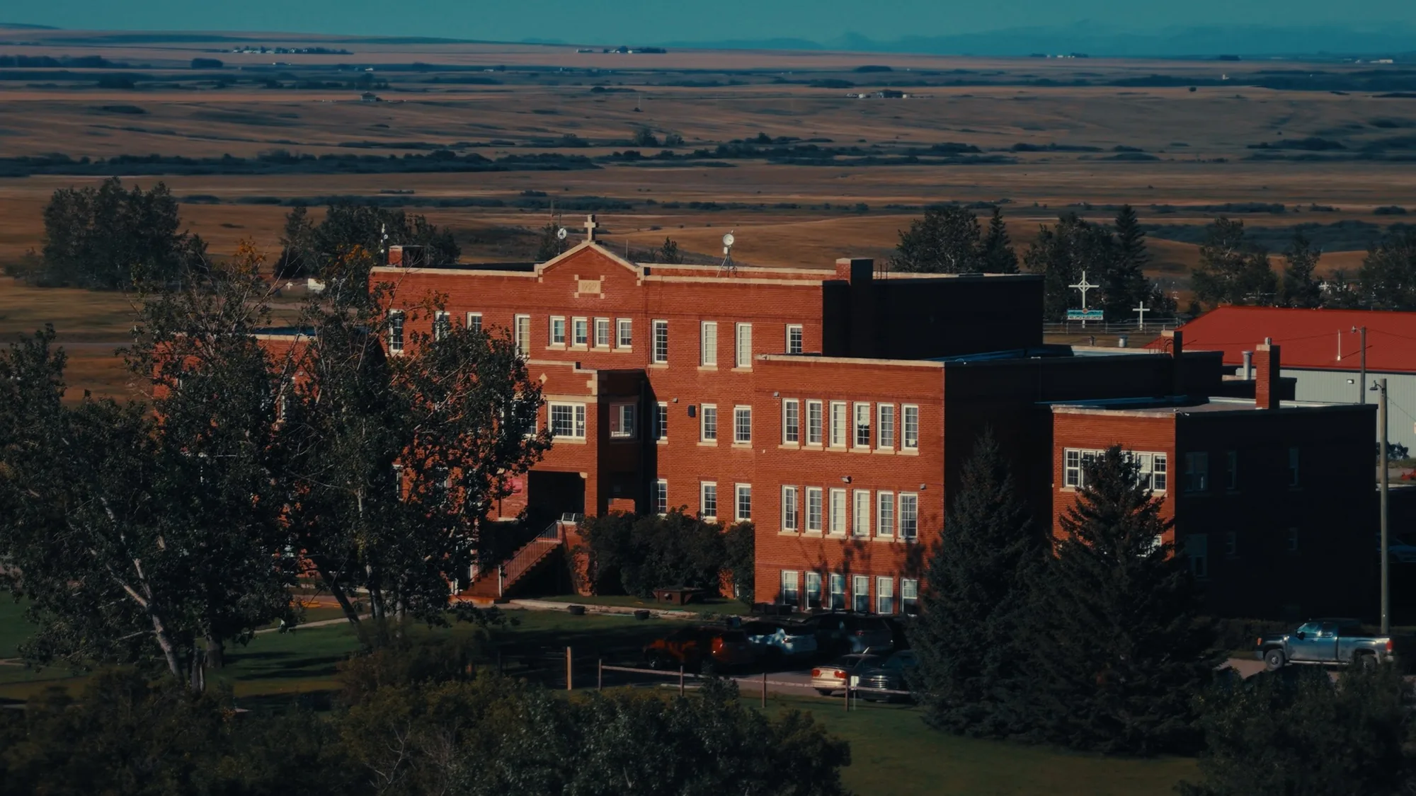 Old Sun Community College on the prairie of Siksika Nation — frame from Natosapi, shot by DCFOTOFILM