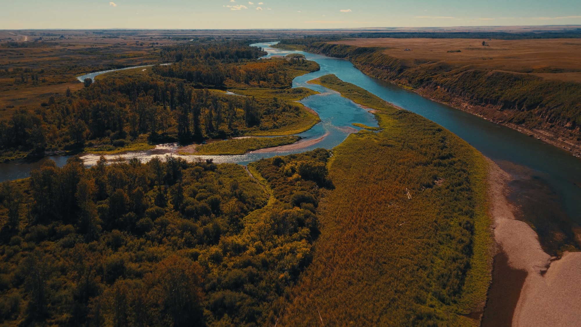 Aerial of the Bow River winding through Treaty 7 land near Blackfoot Crossing — Natosapi