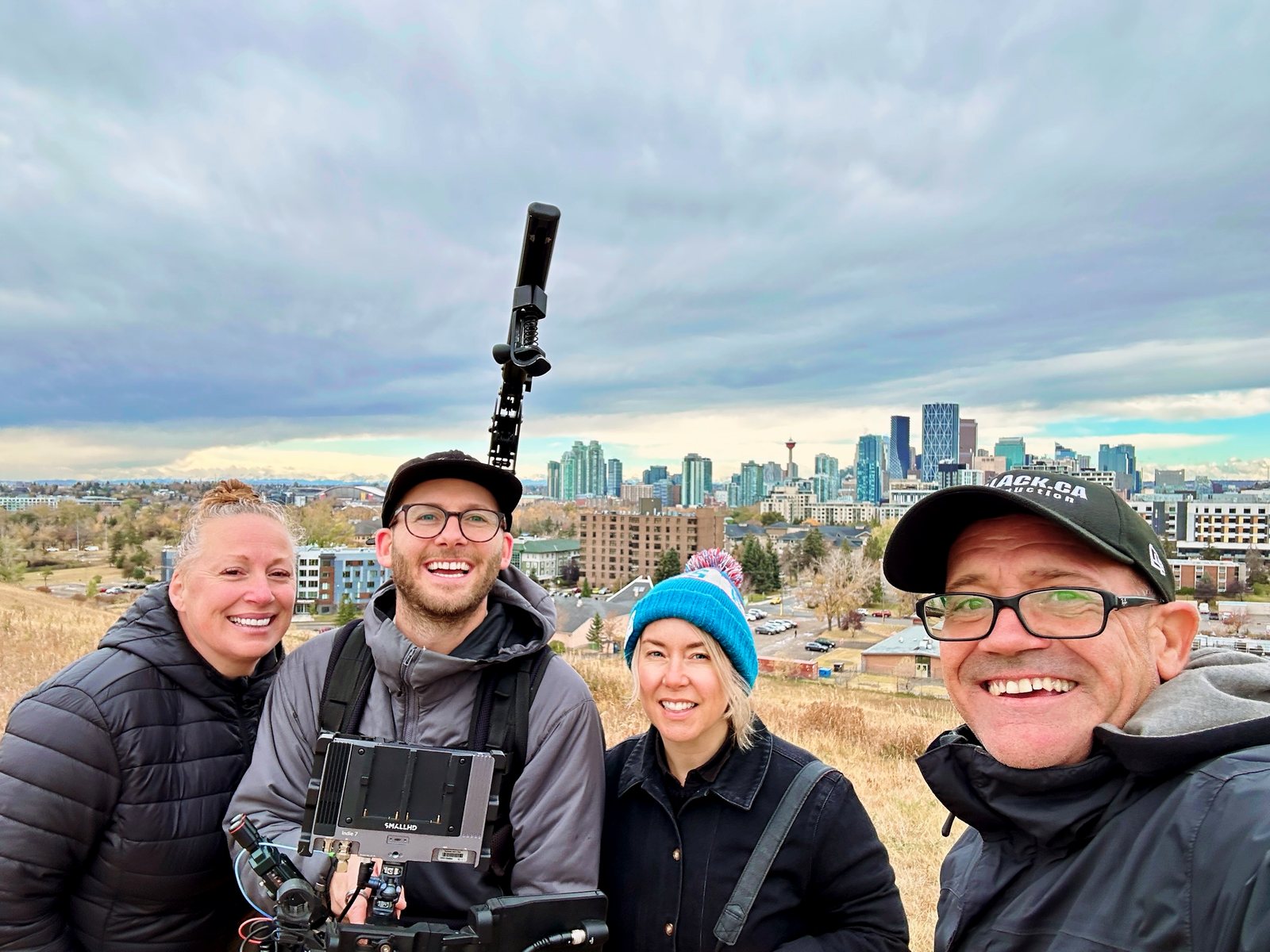 The Calgary film crew for the Toronto Blue Jays campaign, four crew members with a camera rig and the Calgary skyline behind them