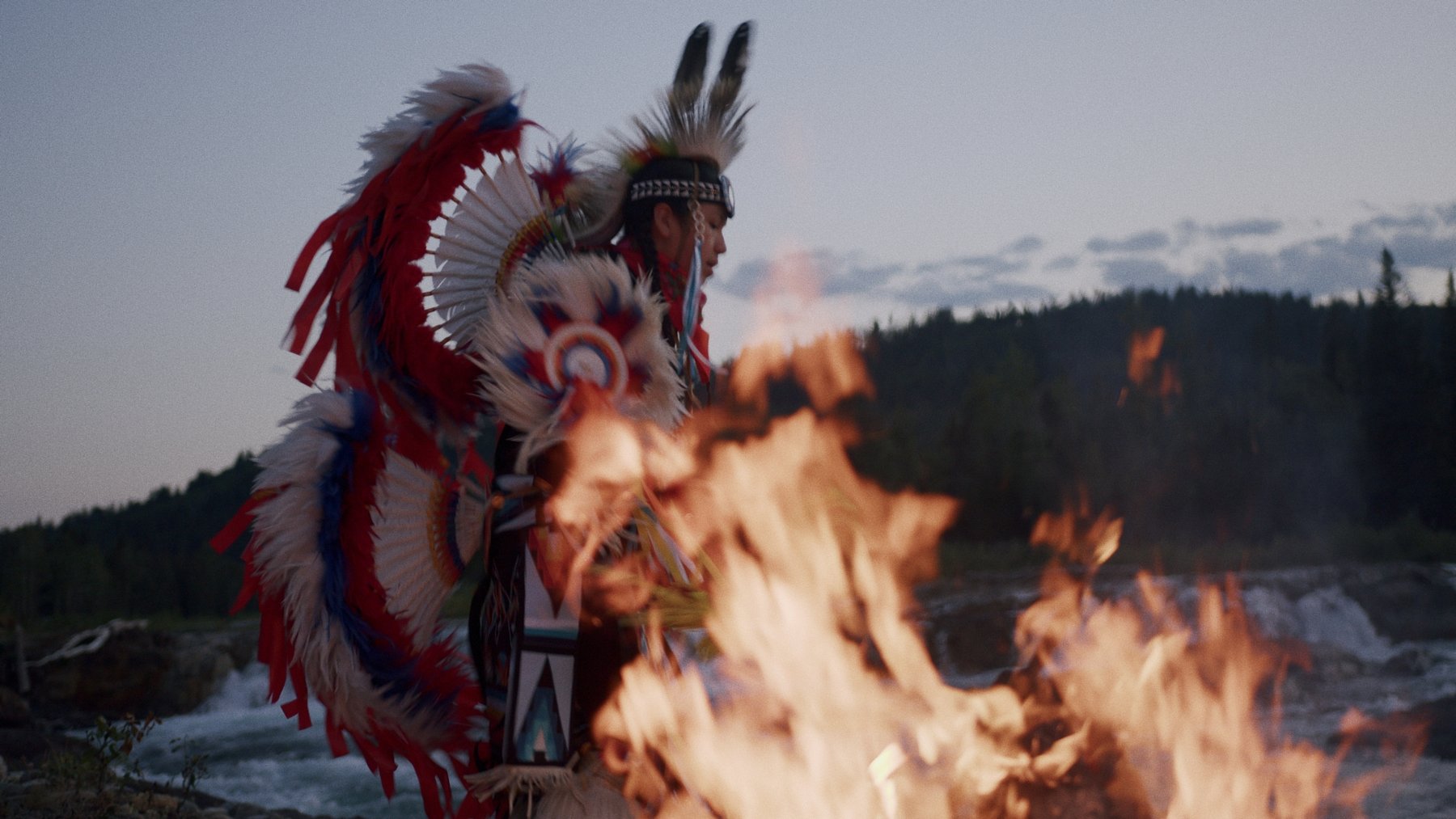 Indigenous dancer in full regalia by fire — Visit Bragg Creek