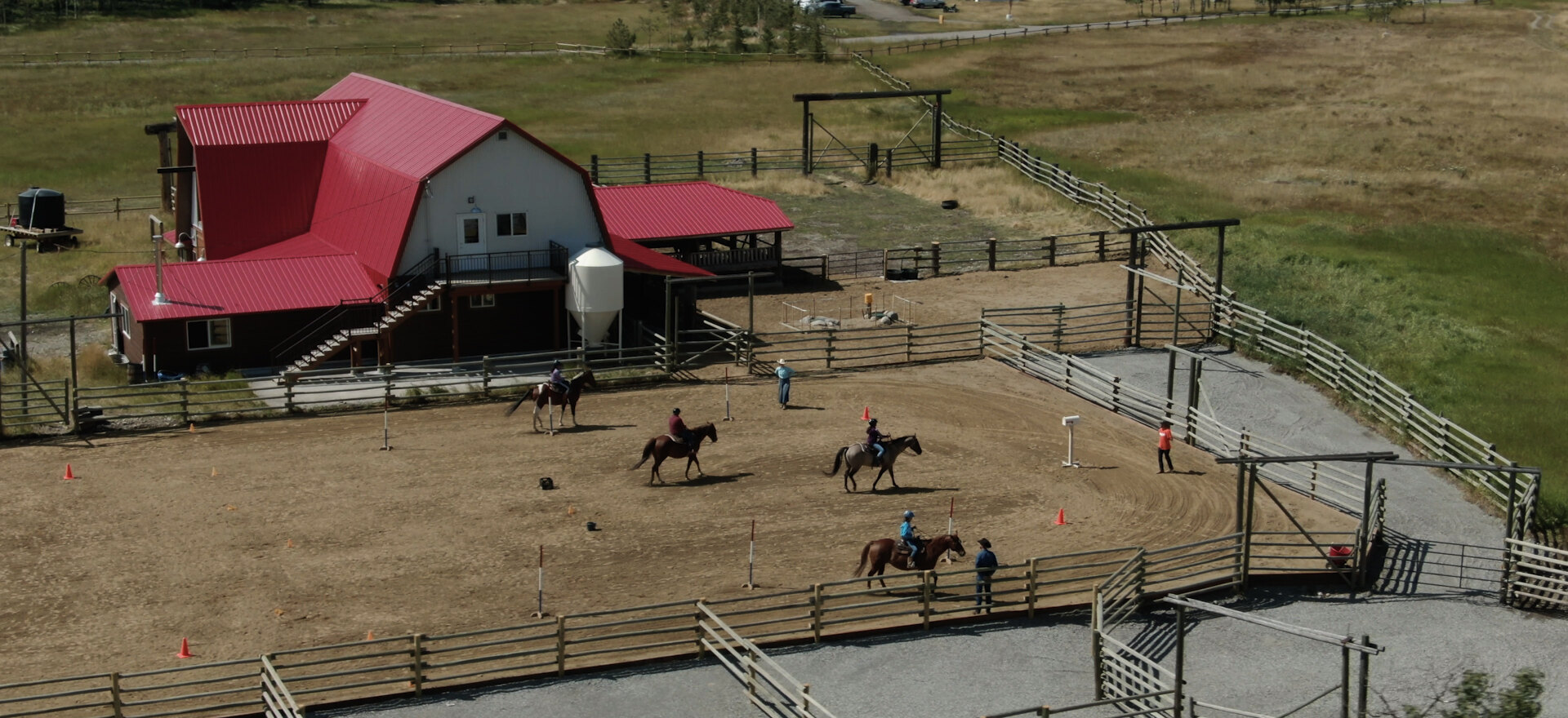 Alberta ranch with riders and corrals from above, aerial photography