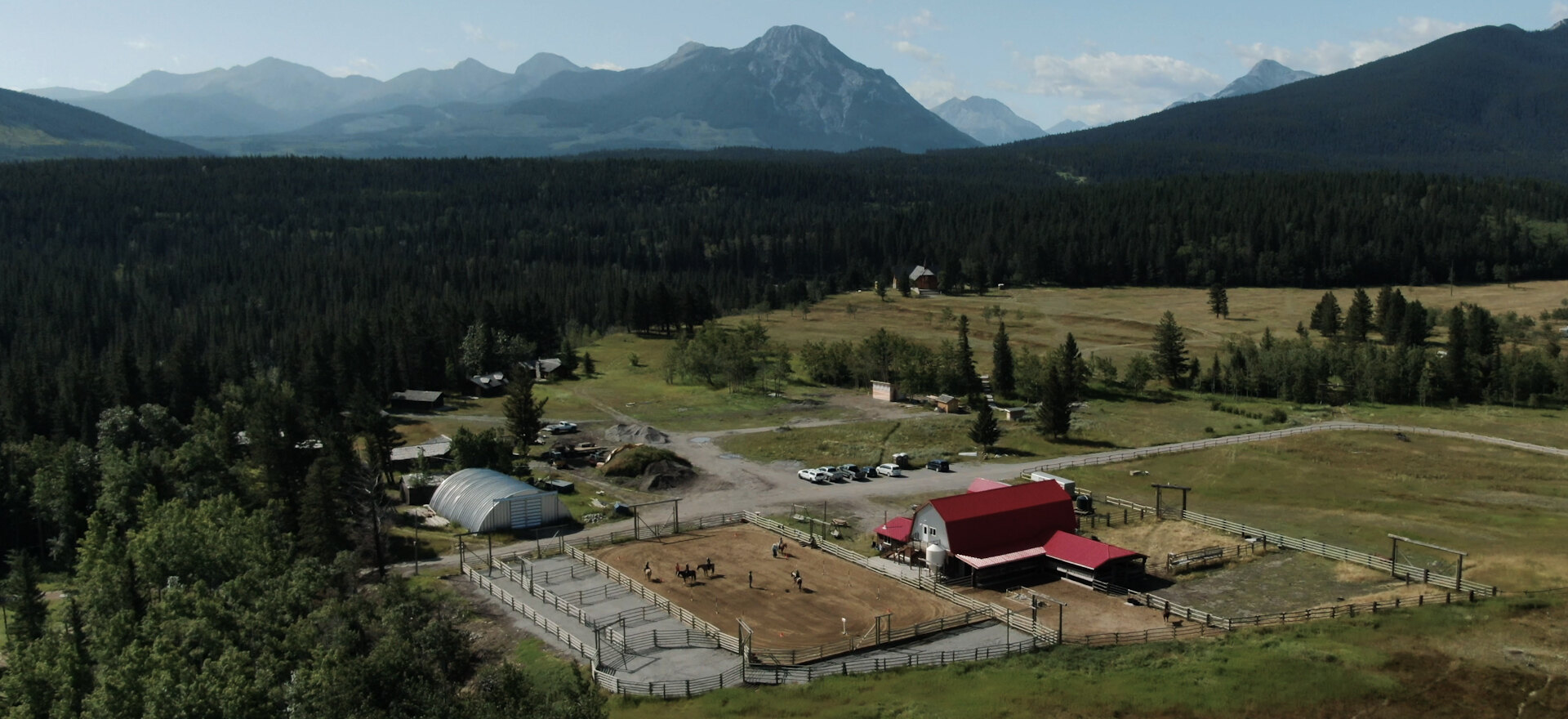 Foothills ranch with Rocky Mountains behind, aerial drone photo
