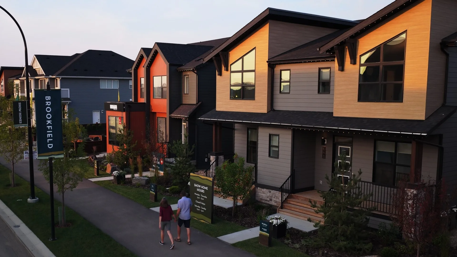 Couple walking the path to a Brookfield show home in a Calgary community, real estate drone photography
