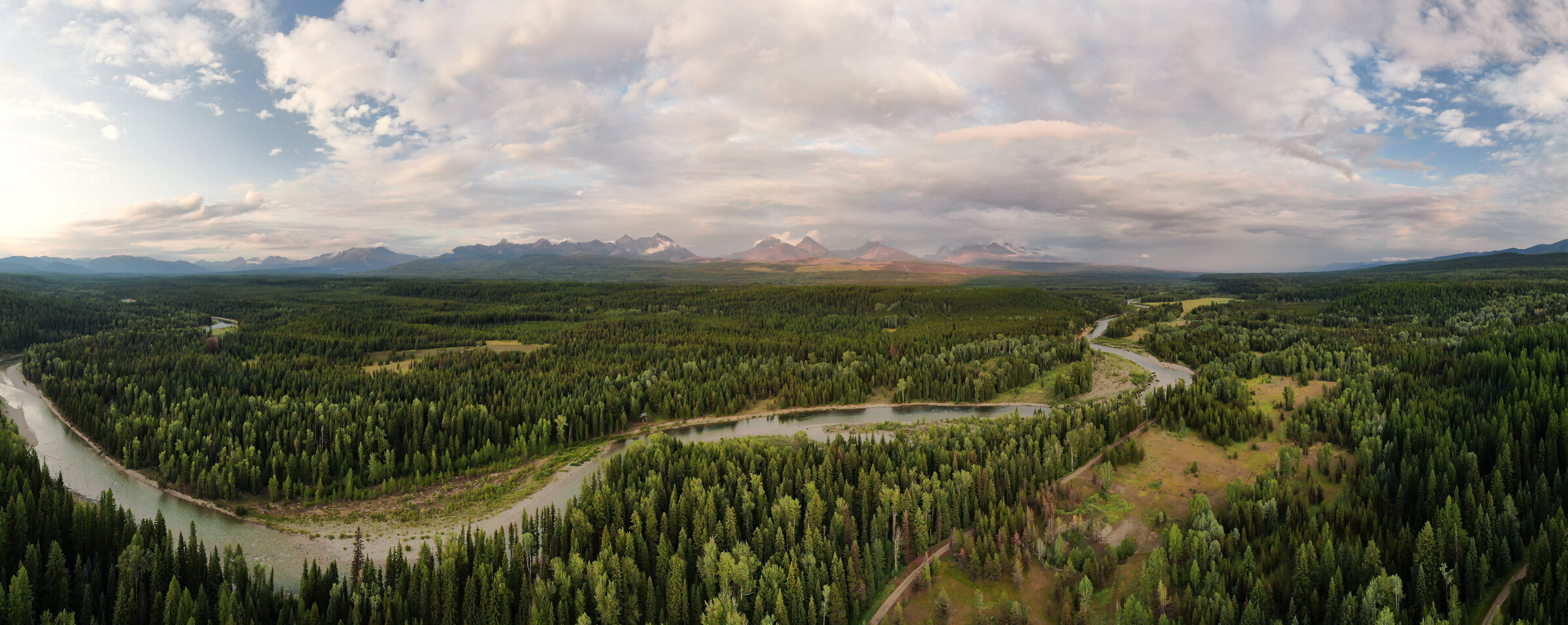 Dusk aerial panorama over the Flathead Valley wilderness with curving river, documentary drone cinematography