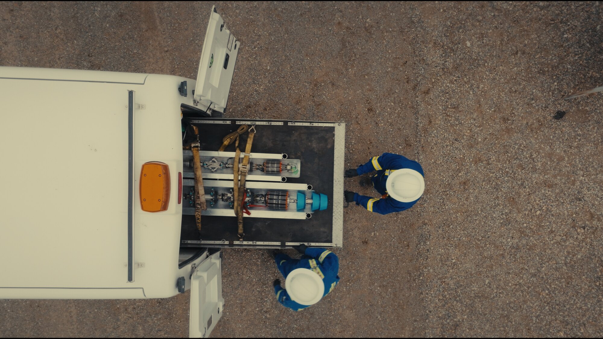 Field crew and equipment from directly above, oil and gas aerial video
