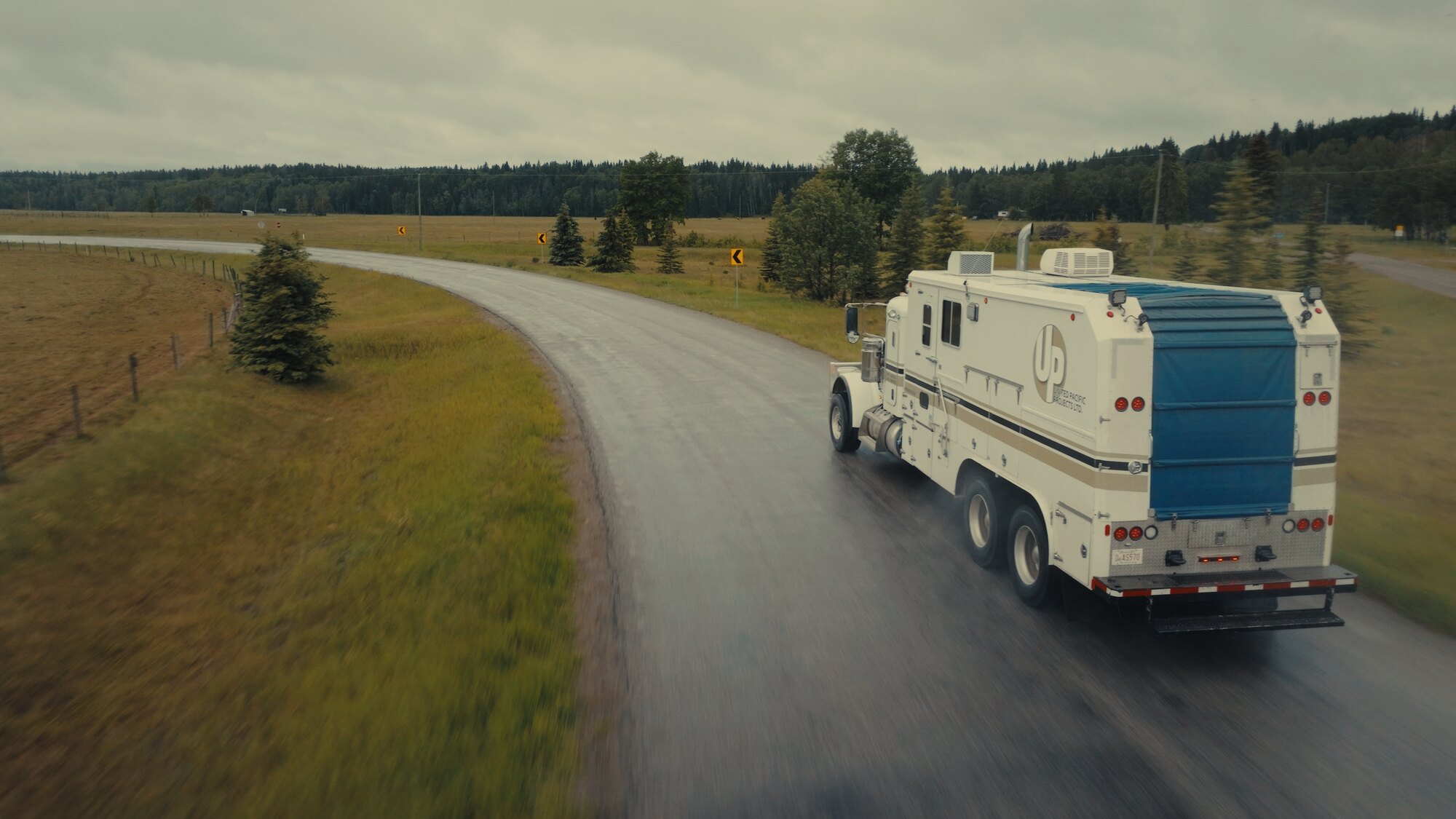 Service truck on a foothills road, aerial tracking shot