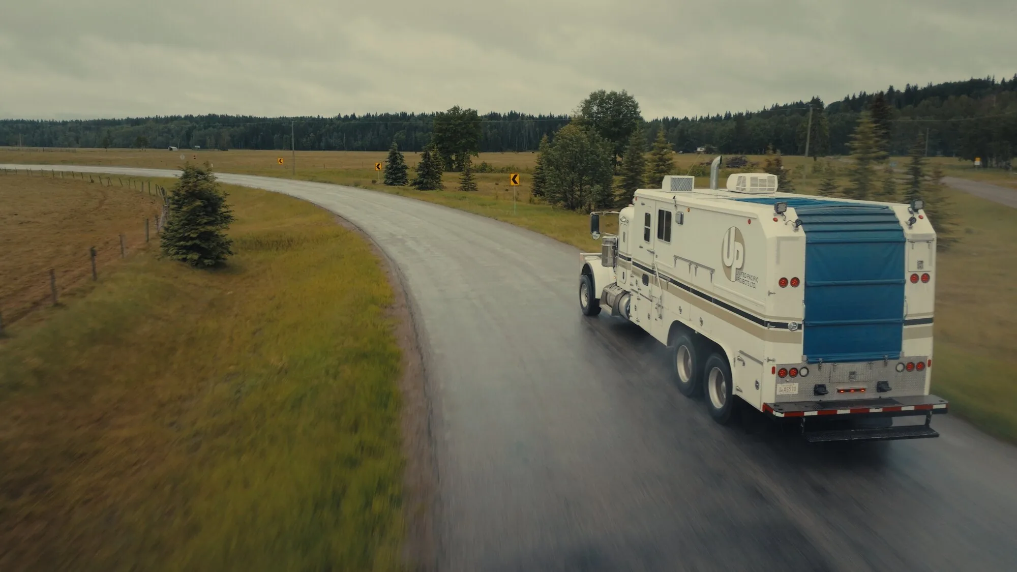 Service truck on a foothills road, aerial tracking shot