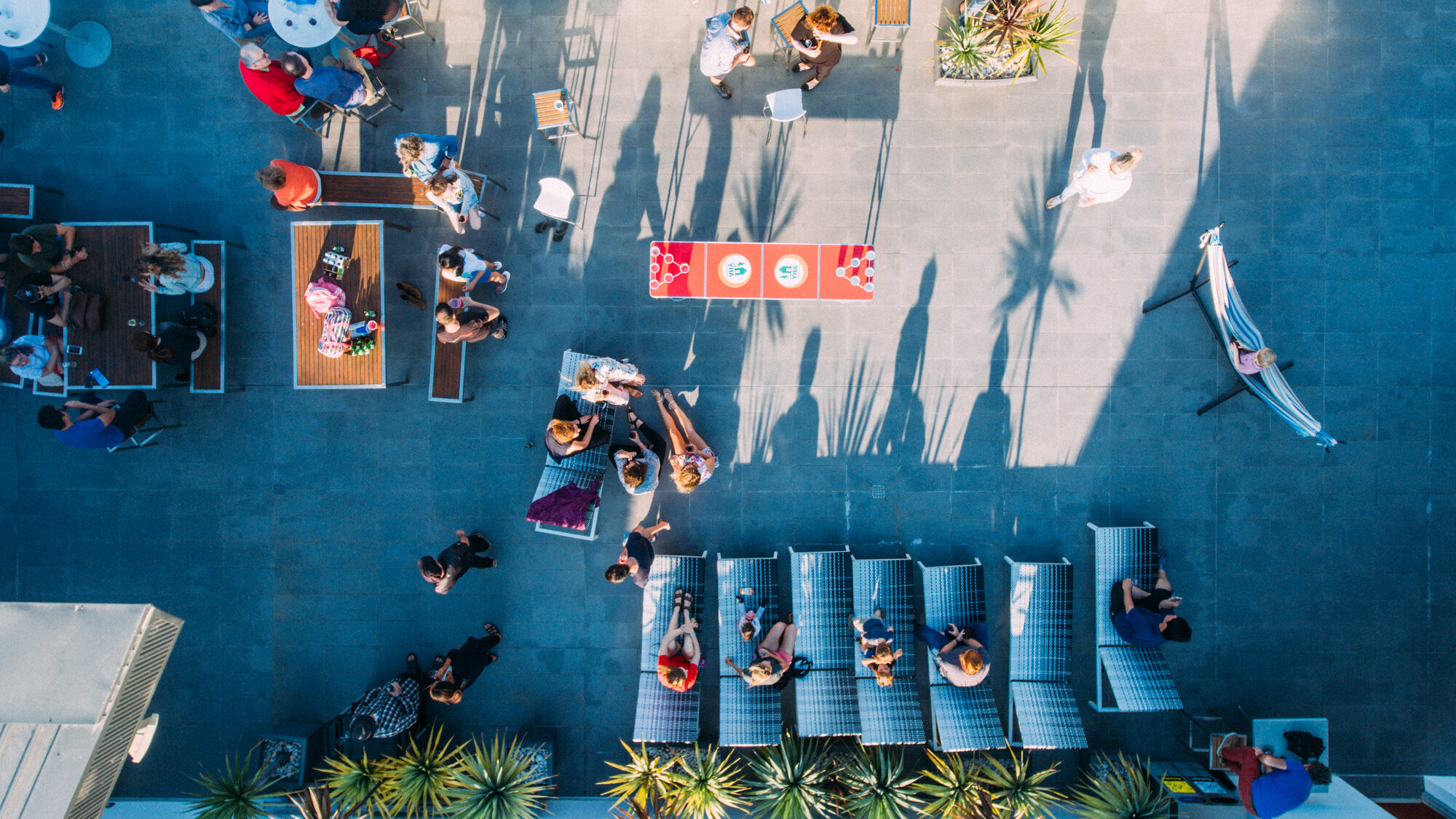 Hostel rooftop deck with guests from directly above, Sydney, hospitality drone photo