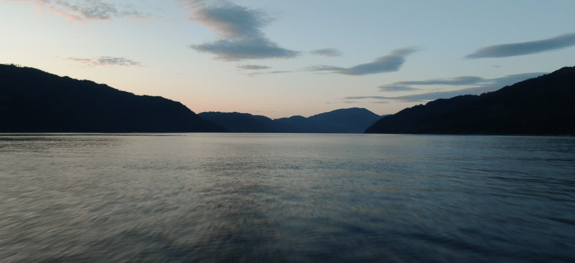 Houseboat on Shuswap Lake at dusk, aerial drone photo for tourism