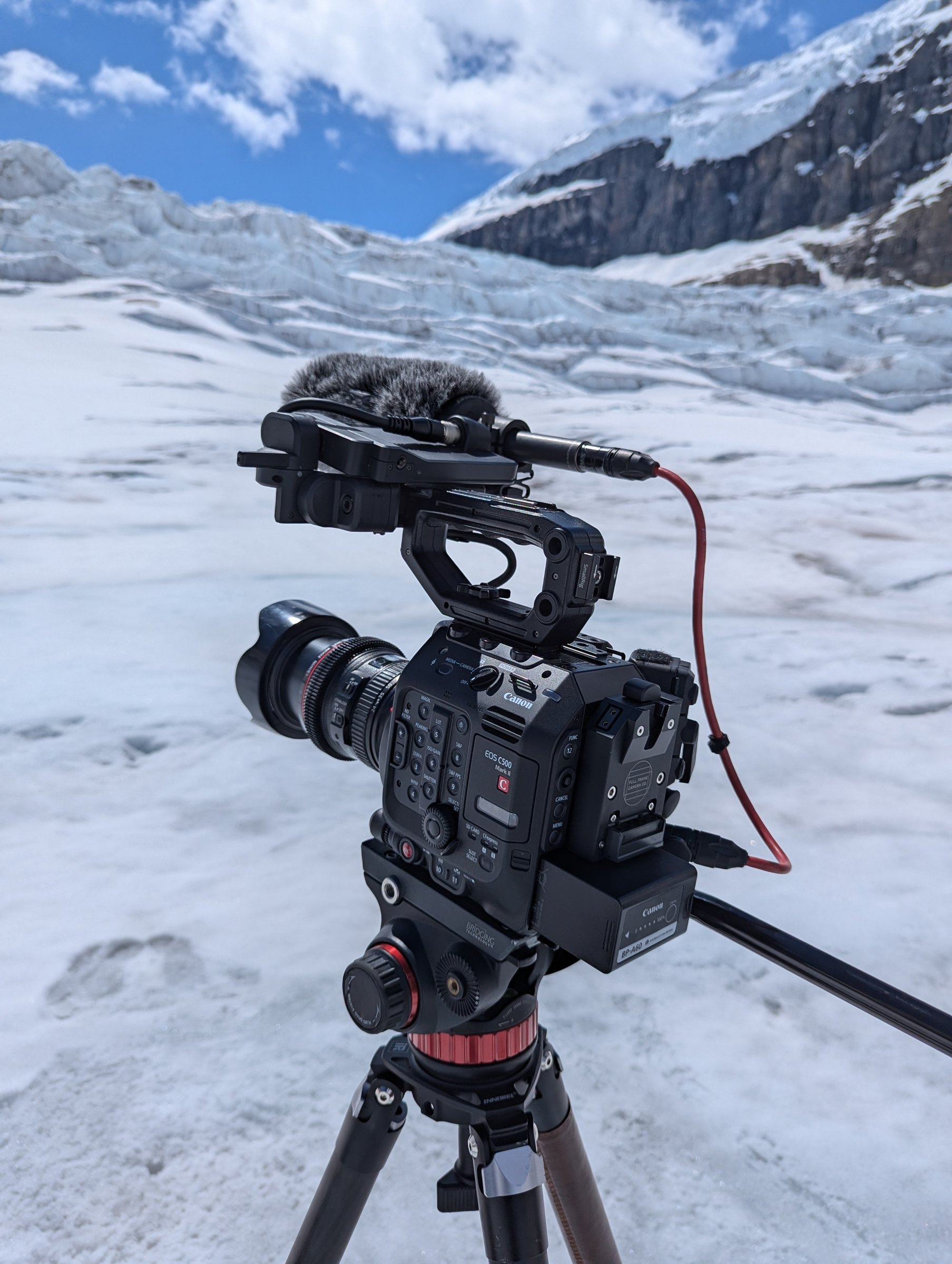 Canon EOS C500 Mark II cinema camera on tripod against Athabasca Glacier crevasse wall — June 2024