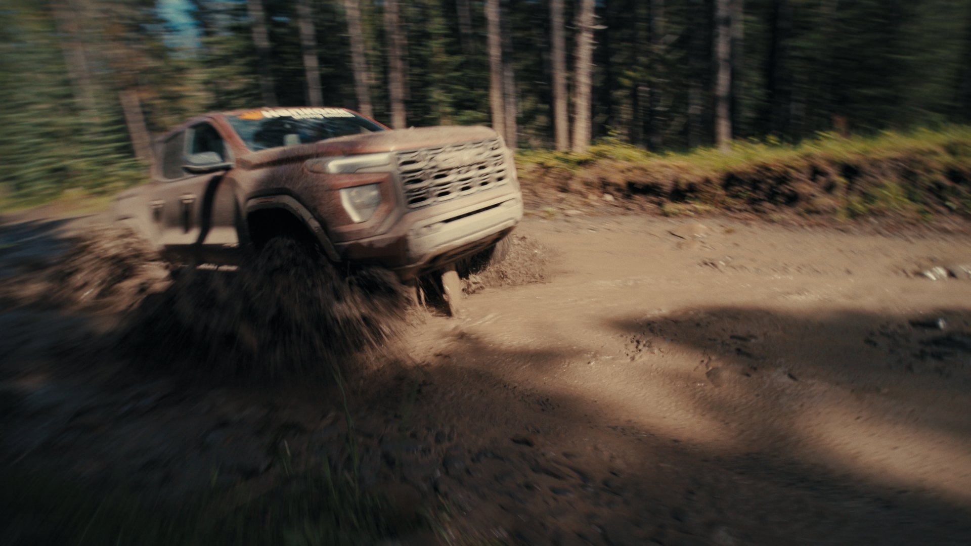 Ford F-150 kicking up dirt on a forest trail — Hankook MT2 commercial frame