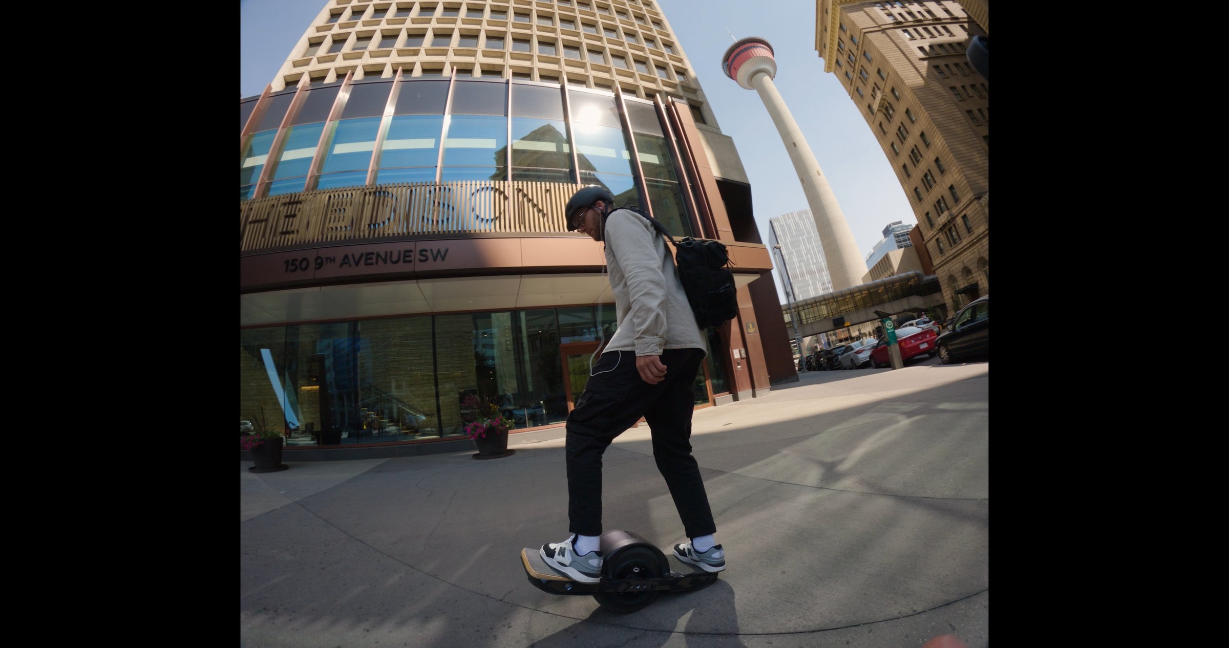 Onewheel commercial frame — downtown Calgary with Calgary Tower, fisheye snorricam