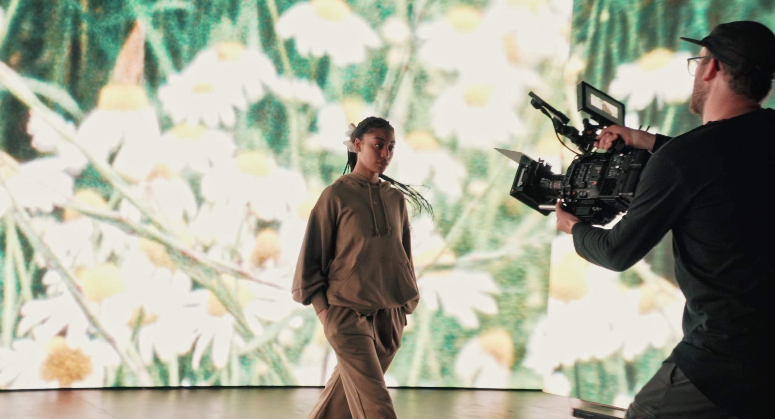 Dave Copithorne shooting a model on an LED volume virtual production stage with a floral backdrop