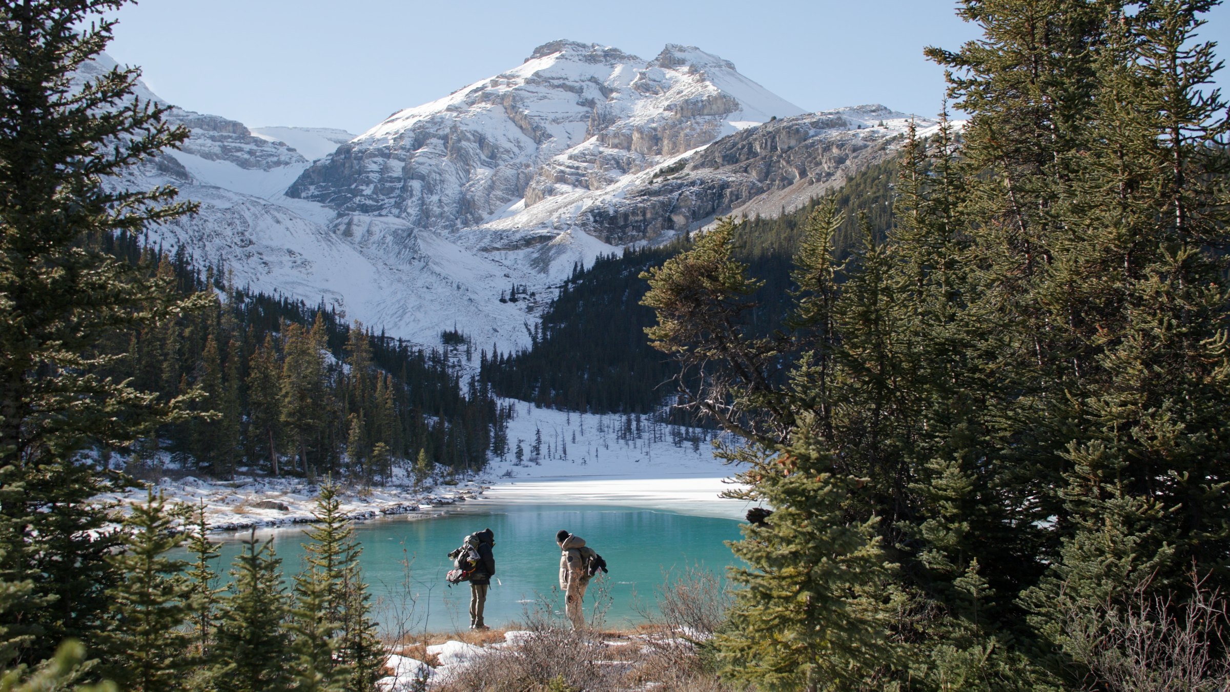 Two figures at a frozen alpine lake — Wild Ice film frame