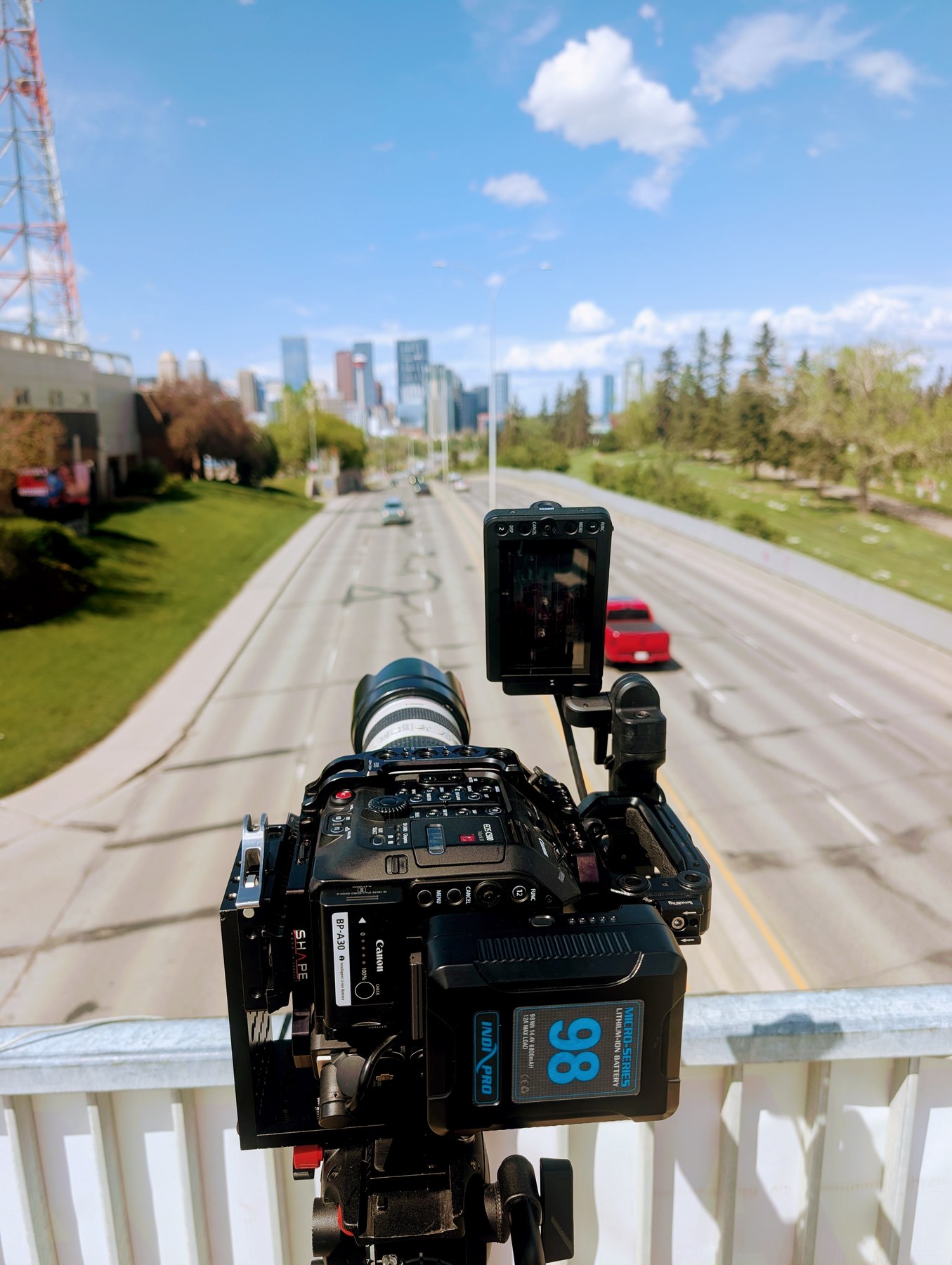 Canon C500 Mark II rigged vertically on bridge railing — Calgary skyline behind, Wealthsimple shoot