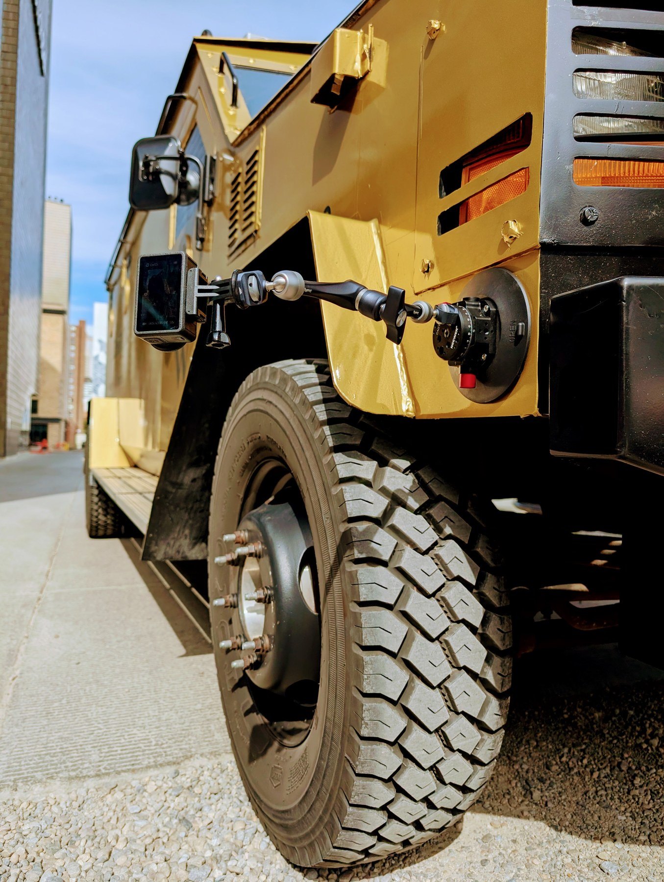 Low-angle POV of Wealthsimple armored truck wheel in downtown Calgary alley — camera rig mounted
