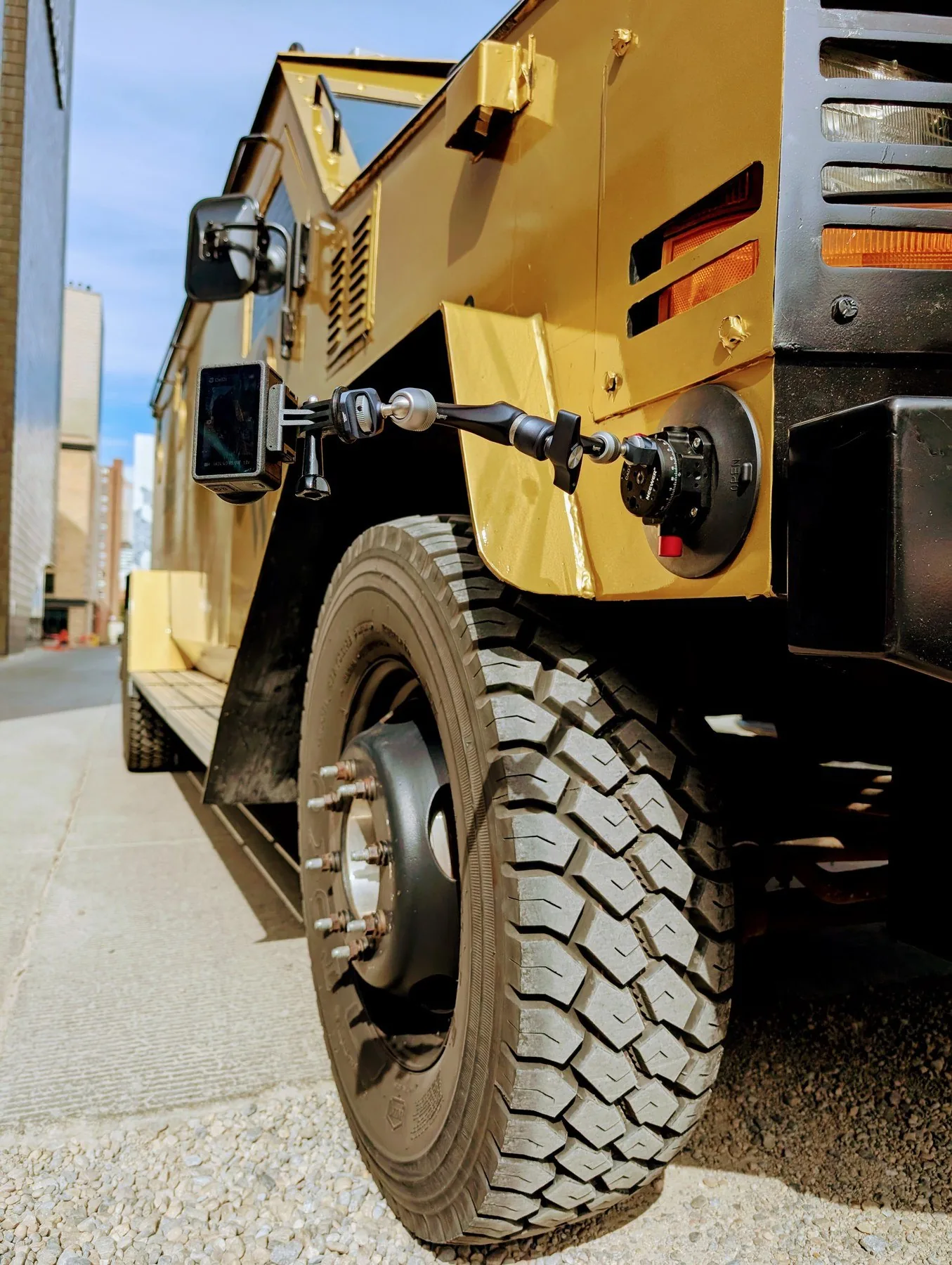 Low-angle POV of Wealthsimple armored truck wheel in downtown Calgary alley — camera rig mounted
