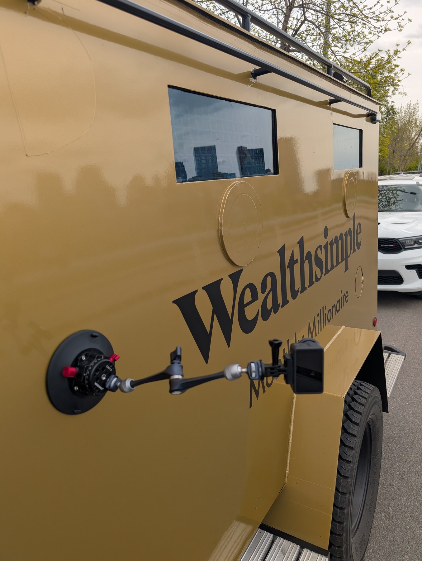 DJI Action 5 camera mounted on Wealthsimple armored truck side — Monthly Millionaire Calgary shoot BTS
